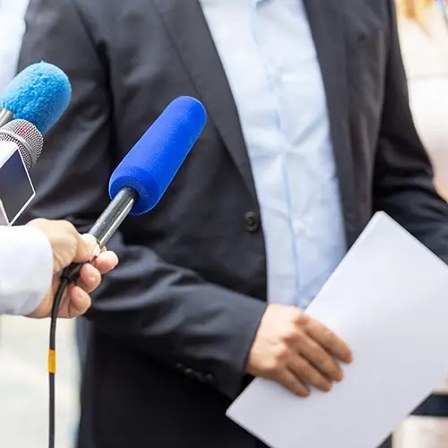 Hand holding microphone with blue sponge