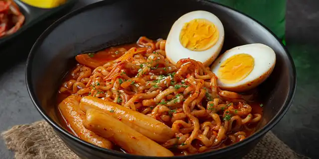 A mouthwatering plate of saucy, red, noodles glistening in the light