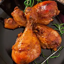 A plate of well seasoned and saucy chicken drumsticks