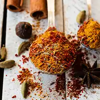 An array of colourful dry spices and seasoning blends in gilted pots