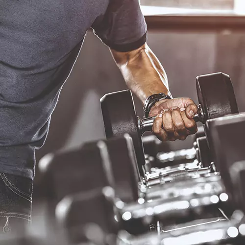 Man picking up a dumbbell at the gym