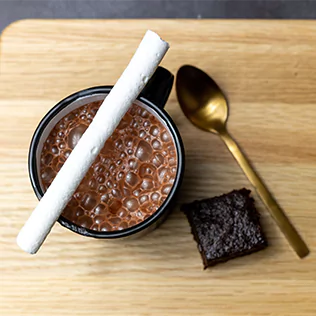 Overheadshot of a coffee mug, spoon, and brownie cake