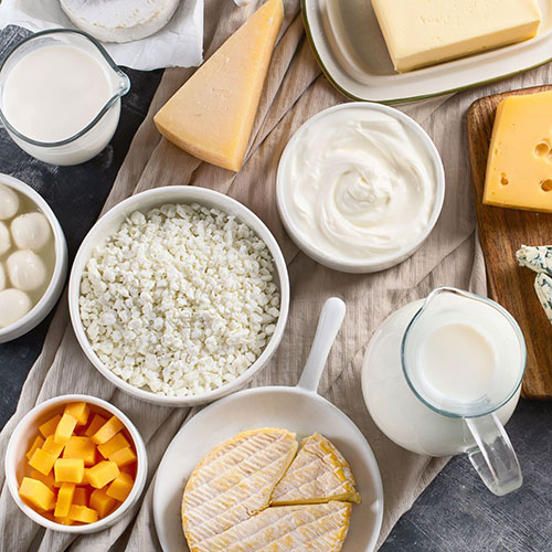 Above shot of a cheese plate filled with various types of cheese and milk