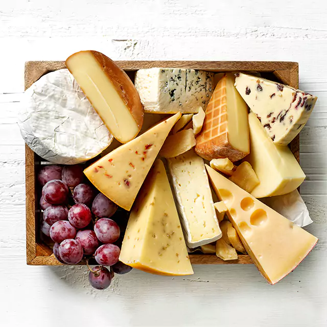 Above shot of a cheese plank filled with grapes and different types of cheese